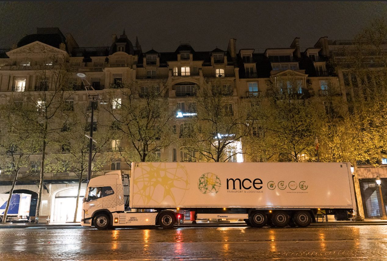 Semi électrique MCE devant une façade haussmannienne